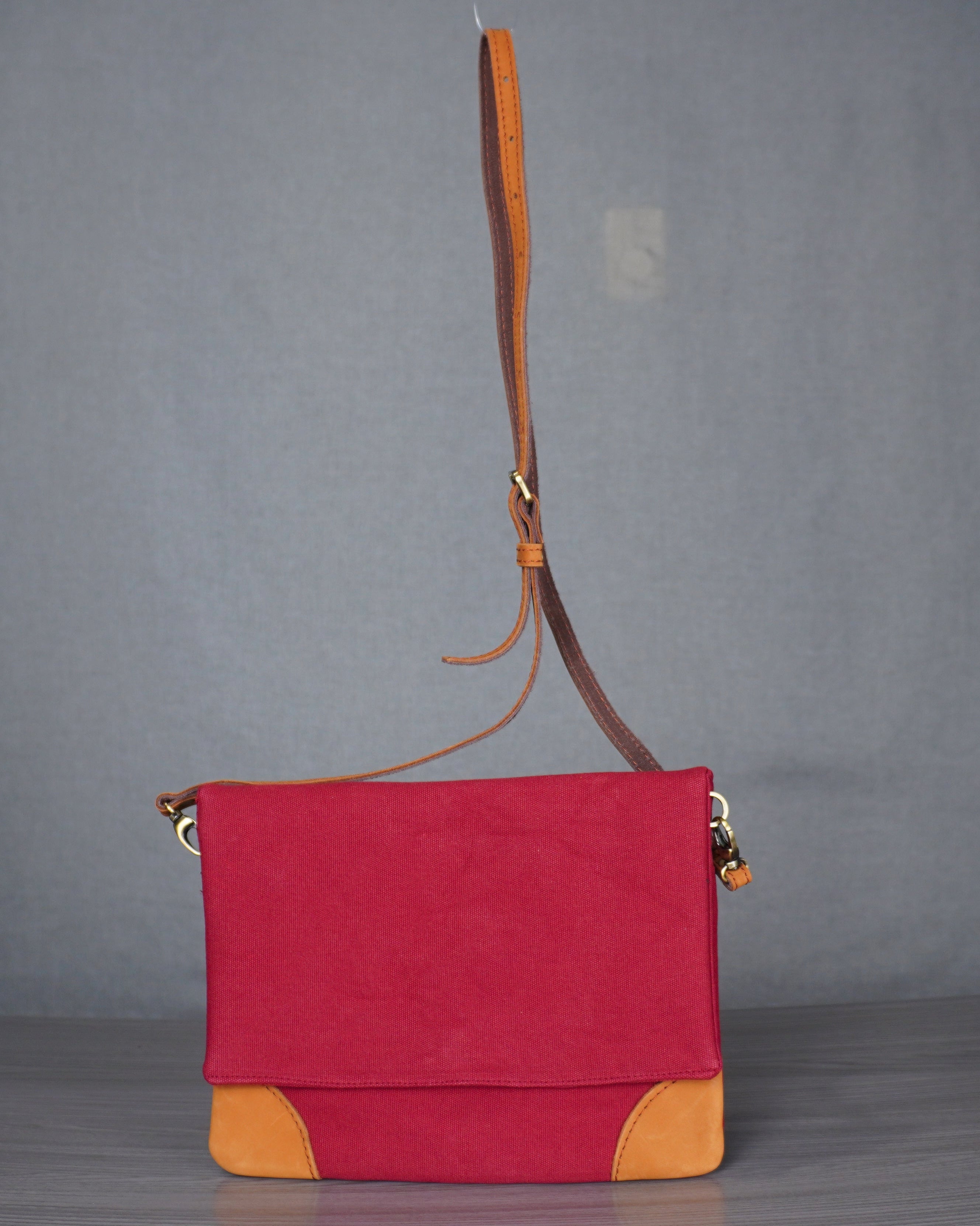 Red and yellow handbag on a gray surface.