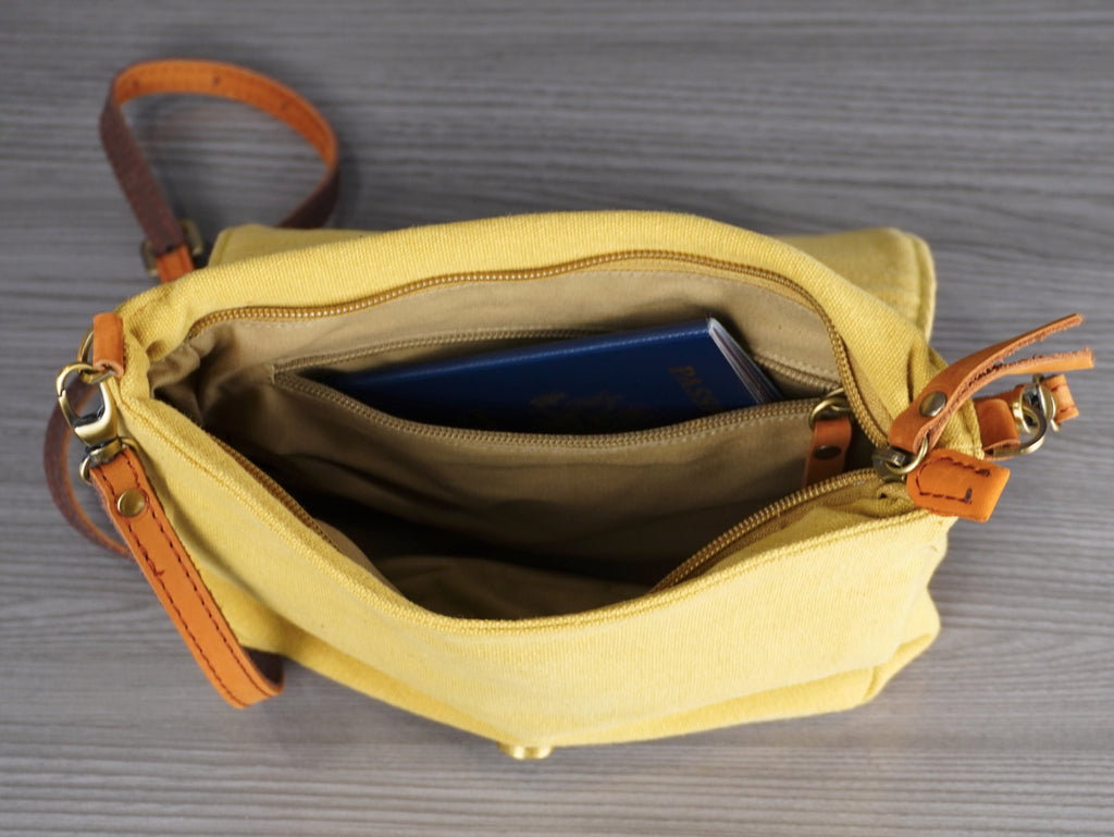 Yellow handbag with brown accents on a gray surface