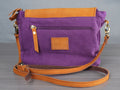 Purple handbag with brown leather accents on a gray surface