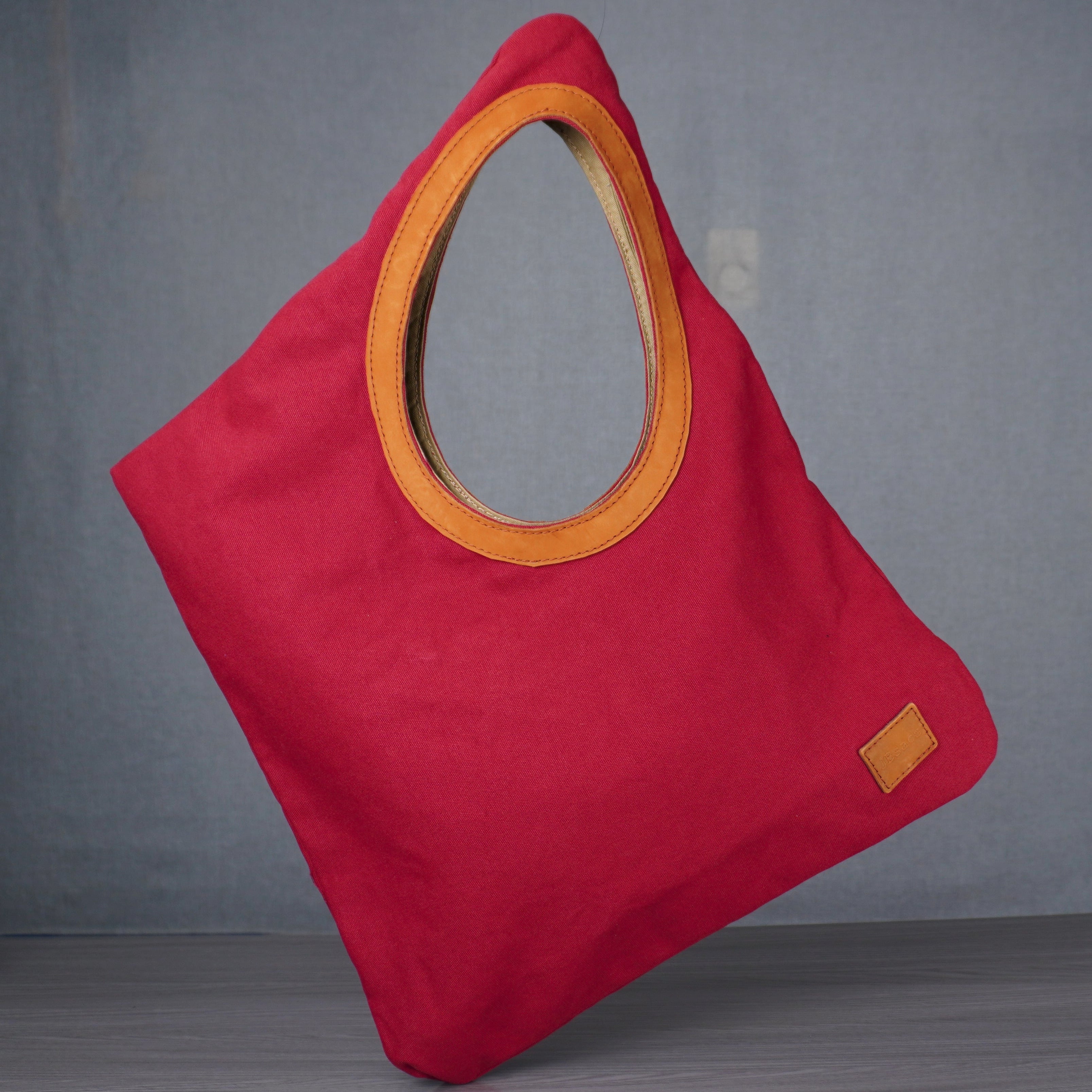Red bag with yellow handle on a gray floor against a white wall