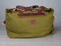 Green bag with brown leather accents on a gray background