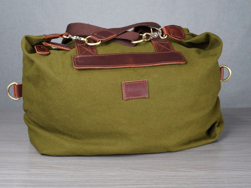 Green bag with brown leather accents on a gray background