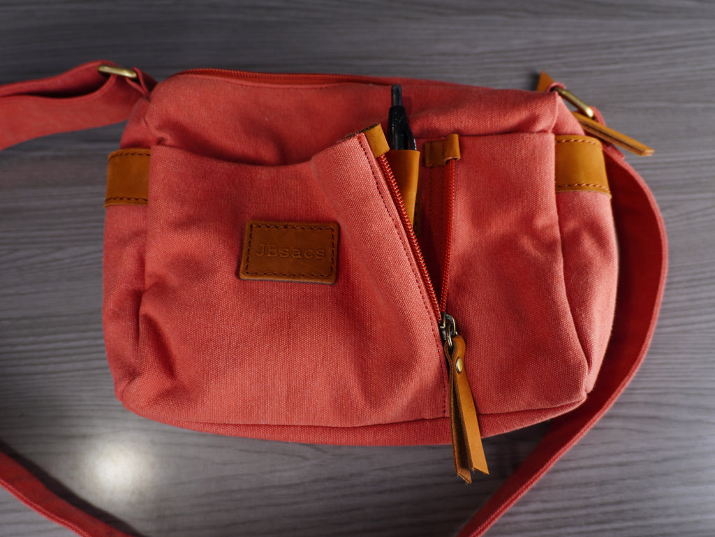 Red bag with brown accents on a wooden surface