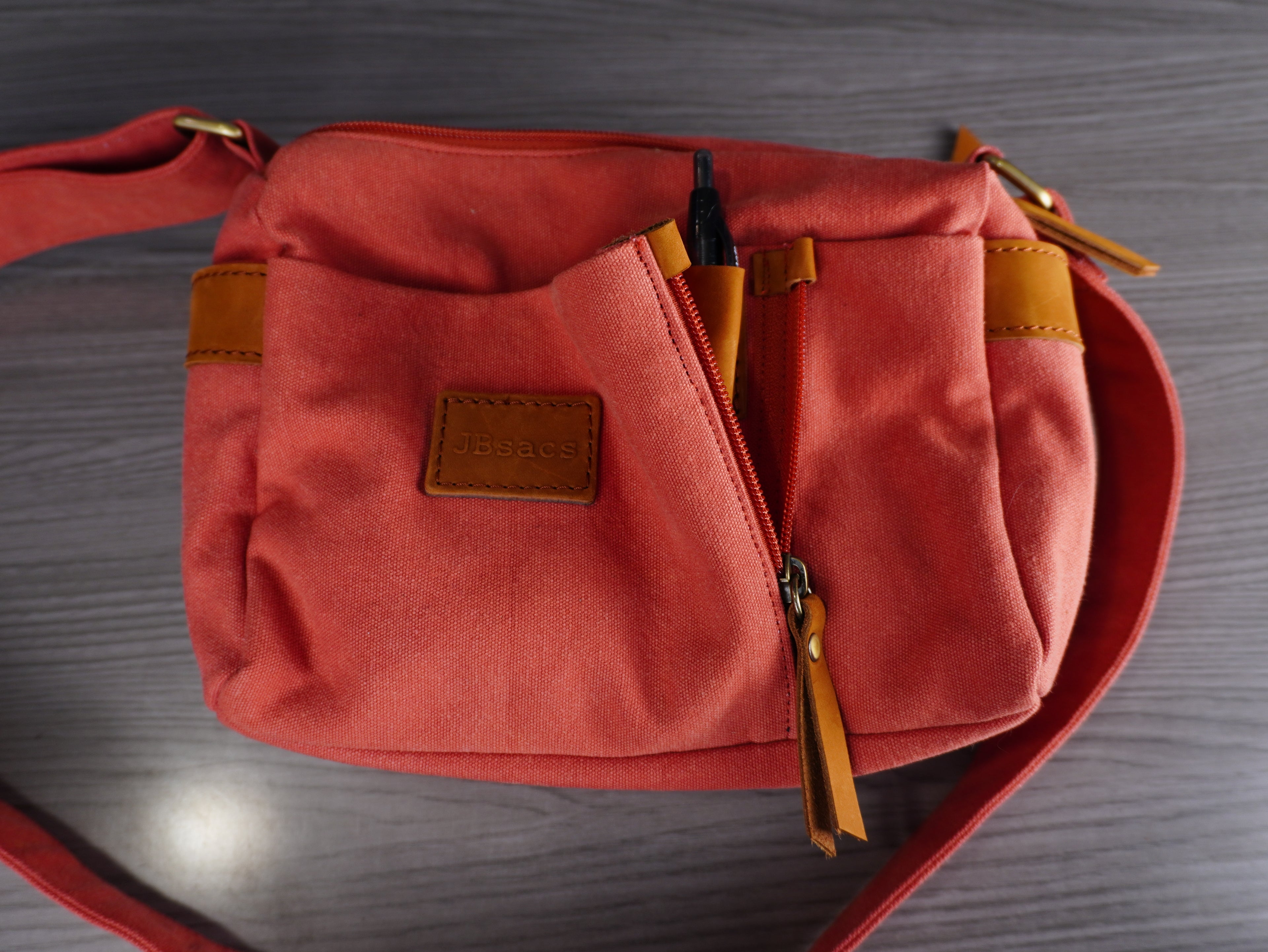 Red bag with brown accents on a wooden surface