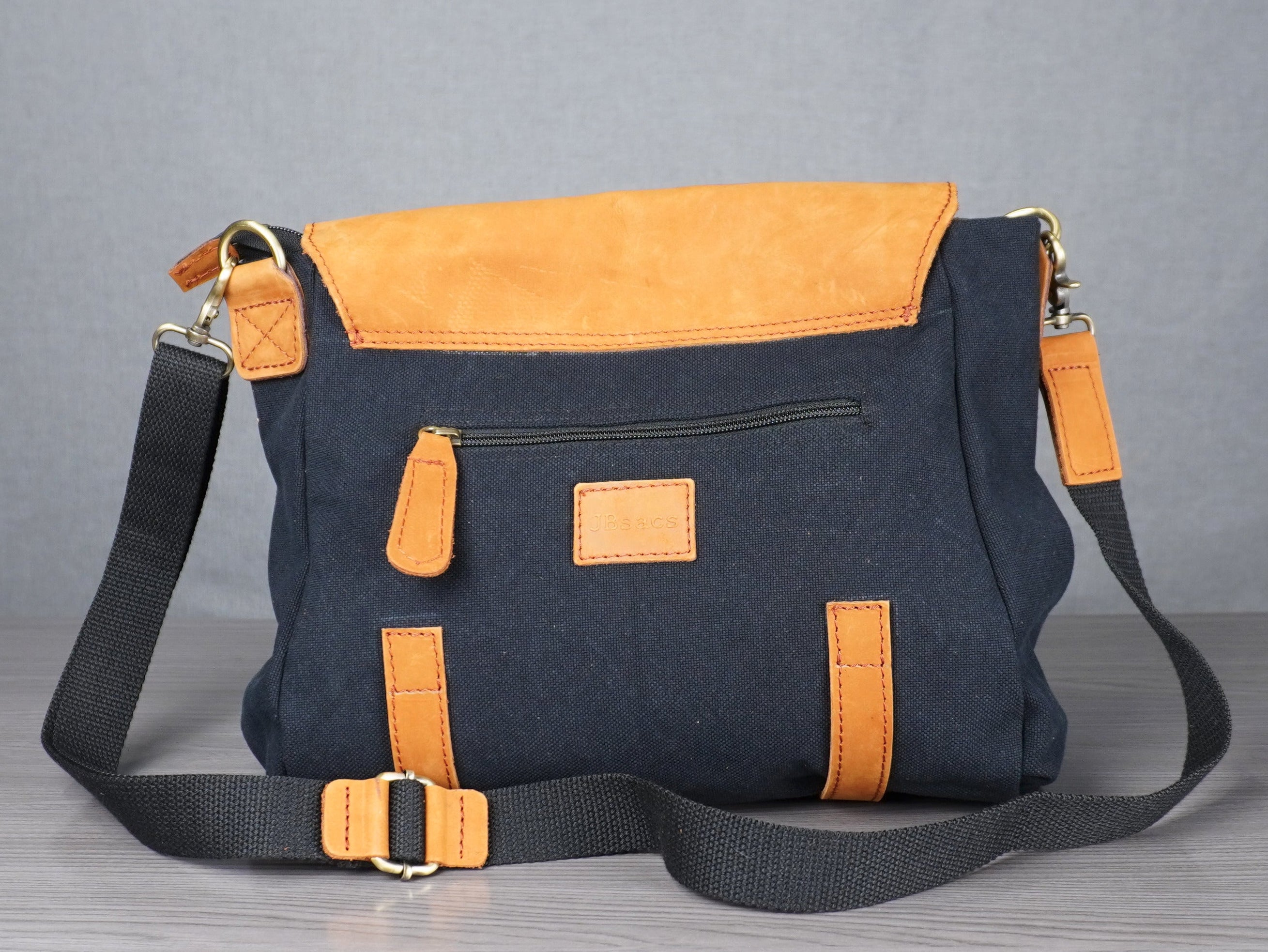 Blue and yellow bag on a metal table with a gray curtain background