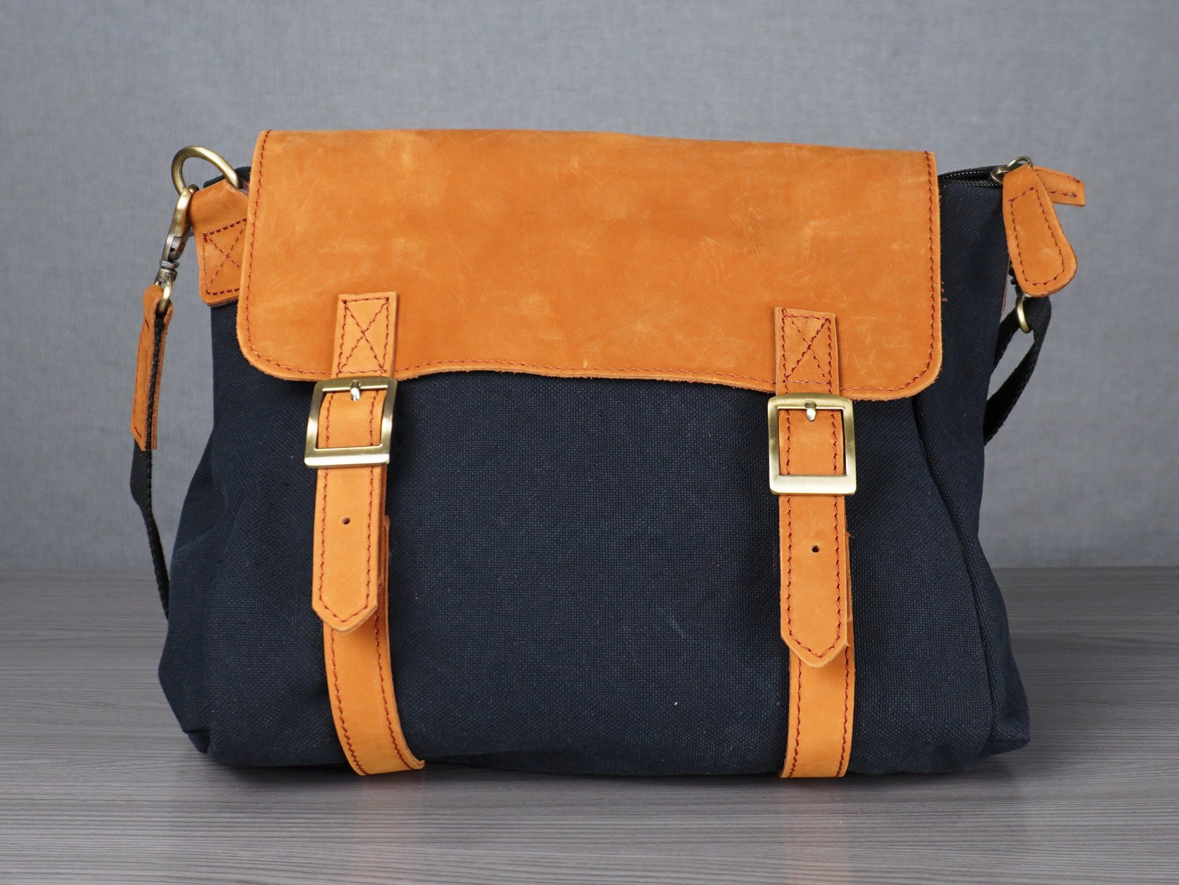 Black and yellow handbag on a metal table with a plain background