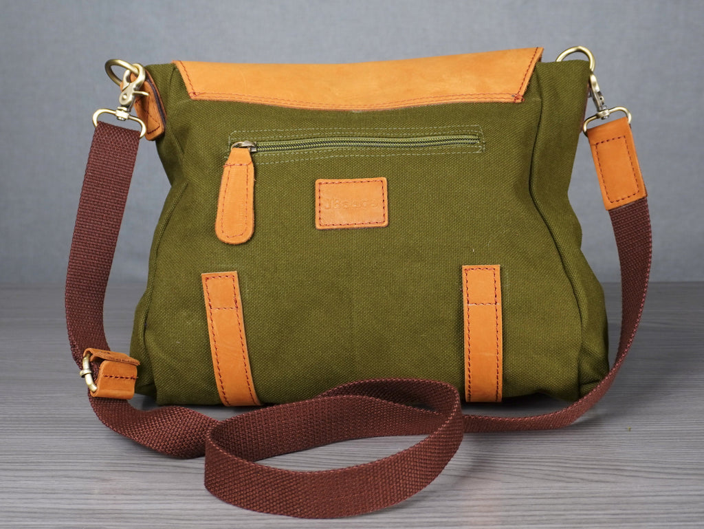Green handbag with brown straps on a gray surface
