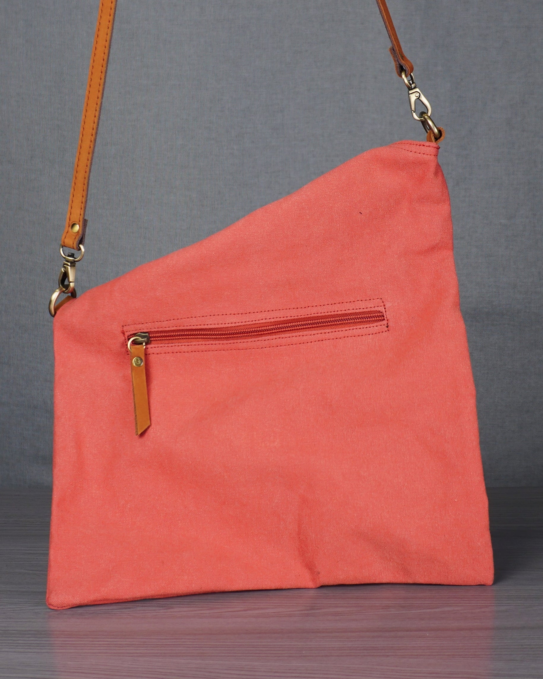 pink bag with leather straps on a grey table