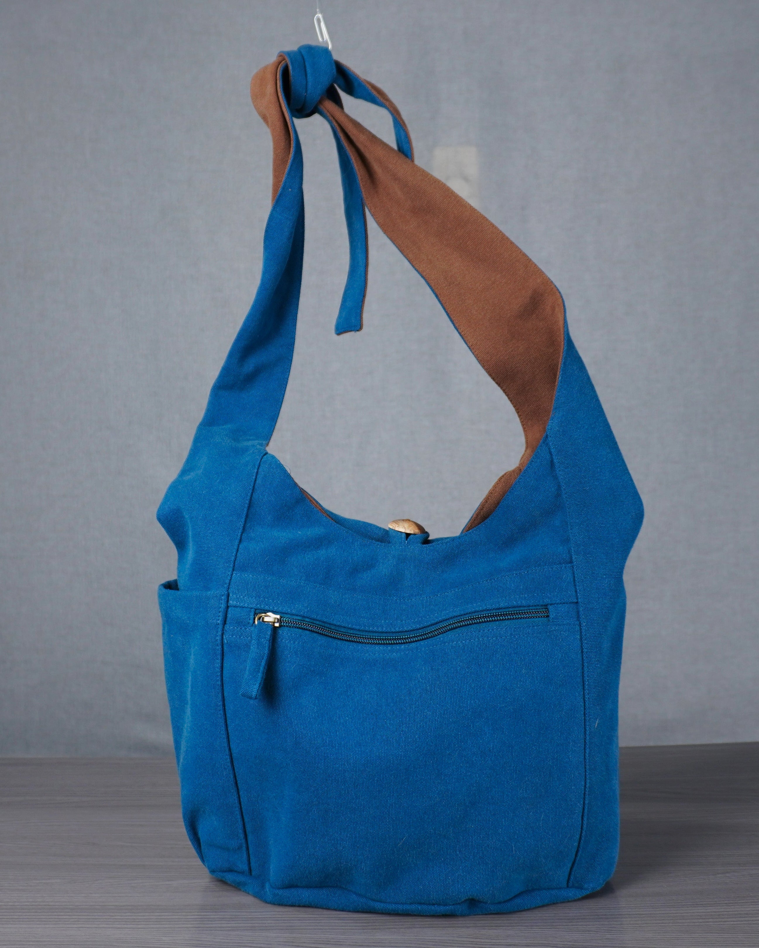 Blue handbag with brown interior on a gray background