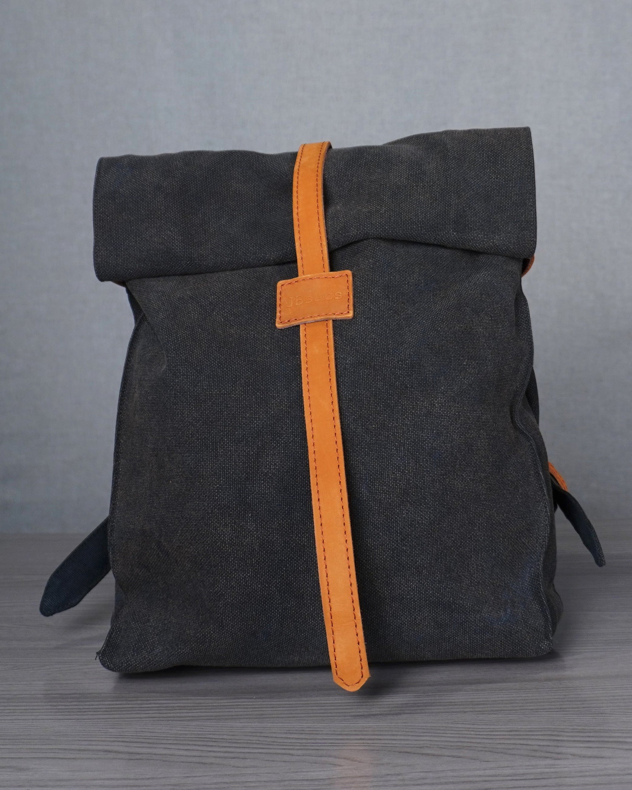 Gray backpack with an orange strap on a gray background