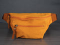 Yellow waist bag on a dark surface with a gray background