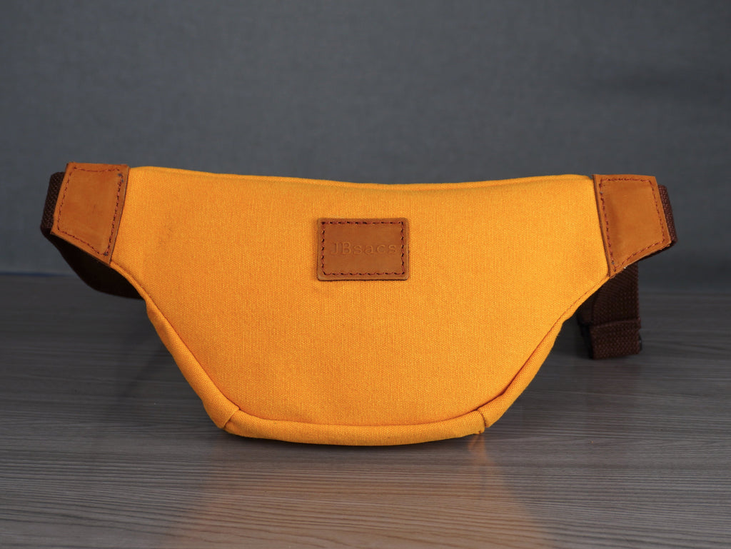 Yellow waist bag with brown accents on a gray surface